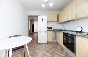 a kitchen with a white refrigerator and a table at 0301 ComfortApartments JK Schastliviy Zhuliany Airport in Kyiv