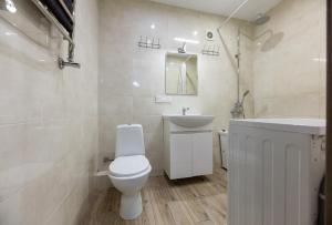 La salle de bains blanche est pourvue de toilettes et d'un lavabo. dans l'établissement 0301 ComfortApartments JK Schastliviy Zhuliany Airport, à Kiev