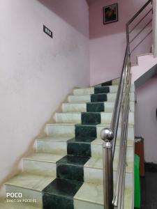 a set of stairs in a house with green tiles at OYO 81239 Shri Vinayaka Inn Rooms in Tiruchchirāppalli