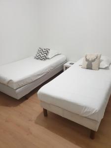 2 nebeneinander sitzende Betten in einem Schlafzimmer in der Unterkunft MAISON A in Saint-Jean-de-Thurigneux