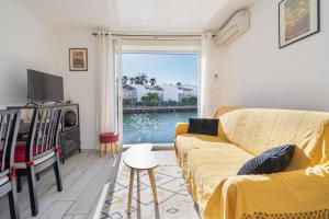 ein Wohnzimmer mit einem Sofa und Blick auf das Wasser in der Unterkunft L'Échappée Marine - Classé 2 étoiles parking privé in Cap d'Agde