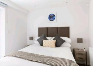 ロンドンにあるPremier Central London North Apartmentの白いベッドルーム(枕付きの大きな白いベッド付)