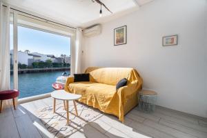 ein Wohnzimmer mit einem Sofa und einem großen Fenster in der Unterkunft L'Échappée Marine - Classé 2 étoiles parking privé in Cap d'Agde