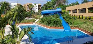 een blauwe waterglijbaan in een tuin met een zwembad bij ApartaSol Reserva de la Colina in La Tebaida