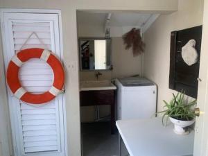 baño con lavabo y salvavidas en Beach Townhouse, near hip strip, beach, airport, en Montego Bay