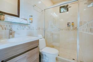 ein Bad mit einer Dusche, einem WC und einem Waschbecken in der Unterkunft Mountain Top Park Hotel in Quepos