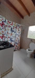 a bathroom with a toilet and a shower curtain at Habitación Juvenil Los Cerros in Paraguarí