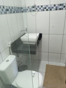 a small bathroom with a toilet and a sink at Pousada das Acacias in Carananduba