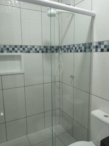 a glass shower in a bathroom with a toilet at Pousada das Acacias in Carananduba