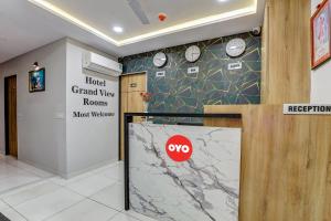 a lobby of a hotel with clocks on the wall at OYO Hotel Grand View in Surat