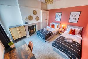 sala de estar con 2 camas y chimenea en 4 Bed Manor Design House, Modern, Spacious- Pet Friendly! Sleeps 9, Portsmouth - By Blue Puffin Stays, en Portsmouth