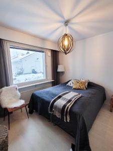 een slaapkamer met een groot bed en een raam bij Nordic lodge in Rovaniemi