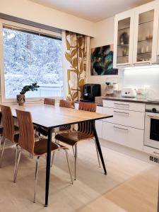 Nordic lodge في روفانييمي: مطبخ مع طاولة وكراسي خشبية
