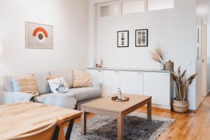 uma sala de estar com um sofá e uma mesa em Scandic Primo Apartments - Malminkatu 49m2 em Helsinque