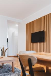 uma sala de estar com uma mesa e uma televisão na parede em Scandic Primo Apartments - Malminkatu 49m2 em Helsinque
