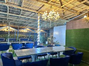 a conference room with a table and blue chairs at Very spacious terrace with rooms for holi party in Gurgaon