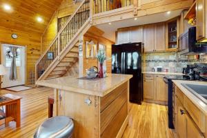 a kitchen with a black refrigerator and wooden cabinets at A Finger Lakes Favorite in Prattsburg