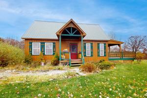 a wooden house with a red door in a field at A Finger Lakes Favorite in Prattsburg