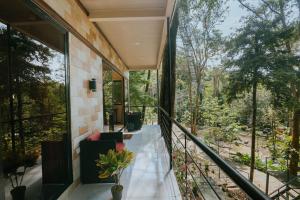 a house in the woods with a balcony at Mountain Top Park Hotel in Quepos