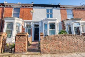a red brick house with a brick fence at 4 Bed Manor Design House, Modern, Spacious- Pet Friendly! Sleeps 9, Portsmouth - By Blue Puffin Stays in Portsmouth