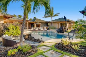 una villa con piscina e palme di Hale Mele Polynesian Pod Style Home with private Pool, Hot Tub, E-bikes and Golf Cart a Waikoloa