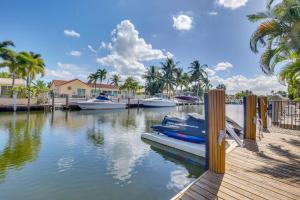 a couple of boats are docked at a dock at Lighthouse Point Home with Pool and Canal Access in Lighthouse Point