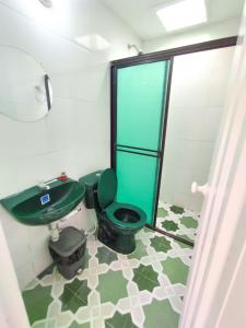 baño con aseo verde y lavamanos en Hospedaje Casa Tito, en Santa Marta