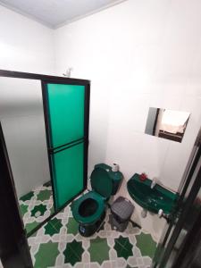 baño con aseo verde y espejo en Hospedaje Casa Tito, en Santa Marta