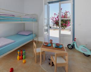 a bedroom with a bunk bed and a table with a tablektop at Athiri Santorini Hotel in Imerovigli