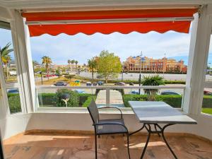 d'une fenêtre avec une table et des chaises et une vue sur la ville. dans l'établissement Laguna Beach Costasol - Alojamientos La Torre, à Torrox Costa