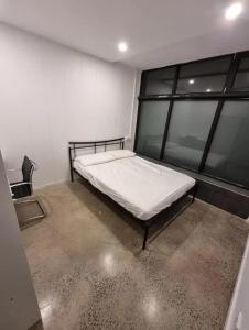 1 dormitorio con 1 cama en una habitación con ventanas en Sydney Airport Guest House en Sídney