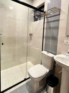 uma casa de banho com um WC e uma cabina de duche em vidro. em Hotel Amaromar em Pontal do Paraná