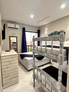a bedroom with two bunk beds and a mirror at Hotel Amaromar in Pontal do Paraná