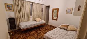 a room with two beds and a television in it at Casa 5 personas. Calle principal Cañuelas in Cañuelas