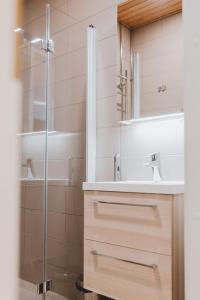 a bathroom with a sink and a shower at Scandic Primo Apartments - Eerikinkatu 46m2 in Helsinki