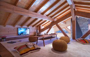 ein Wohnzimmer mit einem Tisch und Stühlen sowie einem TV in der Unterkunft Chalet Norma by Leavetown Vacations in Les Deux Alpes