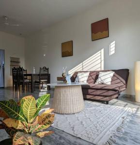 a living room with a couch and a table at Zel’s Stay by Six Lane in Sohāna