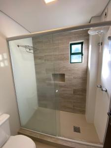 uma cabina de duche em vidro numa casa de banho com WC em Spazio Vital Apartments em Florianópolis