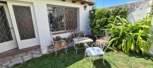 a patio with chairs and a table and a door at Casa 5 personas. Calle principal Cañuelas in Cañuelas