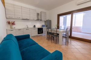 sala de estar con sofá azul y mesa en Nuovi Appartamenti Tri e Bilocali in Residence con Piscina a Porto Cervo 800mt Mare, en Liscia di Vacca