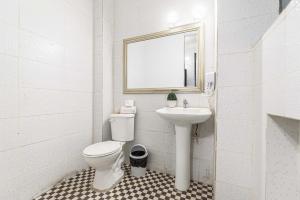 a white bathroom with a toilet and a sink at Santa María Express in Santiago