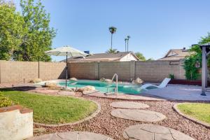a swimming pool with an umbrella in a yard at Family-Friendly Peoria Retreat with Private Pool! in Peoria