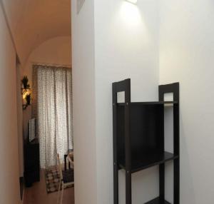 a television on a shelf in a living room at Casa vacanze Ecce Homo in Ragusa +11 photos