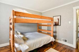 a bedroom with a bunk bed with white sheets at Charming Portland Home, Walk to Light Rail! in Milwaukie