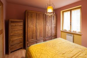 een slaapkamer met een geel bed en een houten kast bij La Fleur, Morgex in Morgex