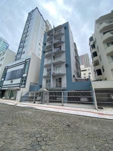 twee hoge gebouwen met een hek voor hen bij Apartamento prox shopping atlântico BrisamarBC5 in Balneário Camboriú