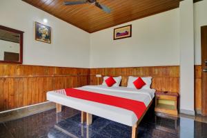 a bedroom with a large bed with red pillows at OYO Flagship 81283 Plaza Residency in Cochin