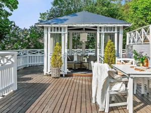 a white gazebo with a table and chairs on a deck at Holiday home Ödsmål II in Ödsmål