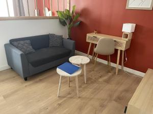 un soggiorno con divano e scrivania di Croix Rouge a Châtellerault