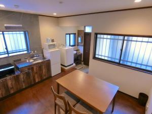 a kitchen with a table and a kitchen with windows at futaba heights - Vacation STAY 15533 in Tokyo